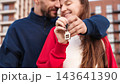 Closeup Happy Couple Embracing And Holding Keys With House Keychain Outside Apartment Building. First Home Purchase, Mortgage, Homeownership And Shared Achievement Concept. 143641390