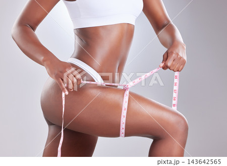 Leg, tape measure and black woman for health in studio, underwear and cellulite for weight loss with fitness, exercise or diet. Person, goal and body progress results of training on white background 143642565