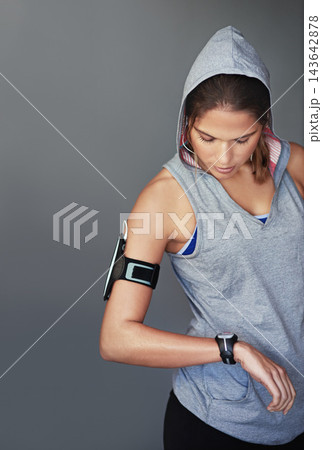 Woman, watch and check for heart rate, wellness and fitness progress with health app and program. Music, blood pressure and workout with training and exercise in a studio with time and headphones Woman, watch and check for heart rate, wellness and fitness progress with health app and program. Music, blood pressure and workout with training and exercise in a studio with time and headphones 143642878