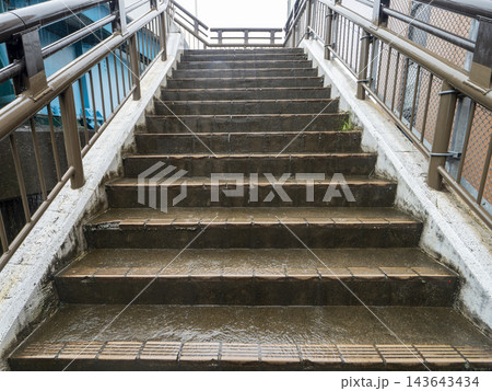 豪雨の雨水が流れる歩道橋の階段 豪雨の雨水が流れる歩道橋の階段 143643434