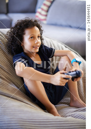 Boy, child and video game on sofa in home with smile, relax and strategy for challenge in living room. Kid, gamer and controller for esports, contest and online competition on couch in family house Boy, child and video game on sofa in home with smile, relax and strategy for challenge in living room. Kid, gamer and controller for esports, contest and online competition on couch in family house 143644451