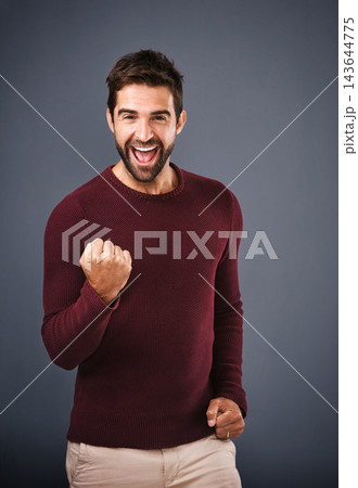 Success, fist and excited man in studio with celebration, achievement or yes for bonus, competition or lottery. Happy winner in portrait with motivation for news or opportunity on gray background 143644775