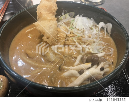 天ぷらとキノコが乗った熱々のカレーうどん 天ぷらとキノコが乗った熱々のカレーうどん 143645385