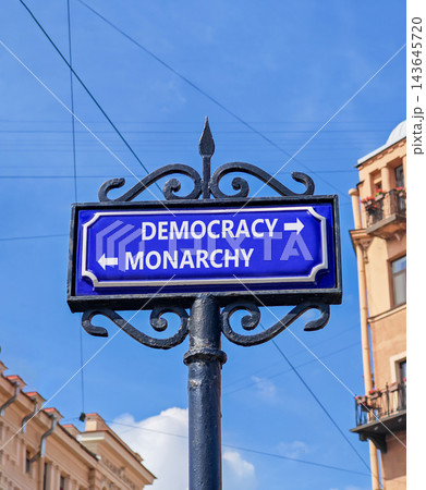 Democracy or monarchy words symbol. Concept words Democracy Monarchy on beautiful blue road sign. Beautiful blue sky background. Business democracy monarchy concept. Copy space 143645720