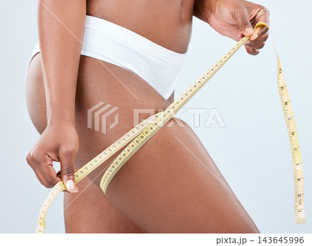 Woman, thighs and body with tape measure in studio on white background with underwear, progress and weight loss. Female person, fitness and legs with results for self care, monitor health and shape Woman, thighs and body with tape measure in studio on white background with underwear, progress and weight loss. Female person, fitness and legs with results for self care, monitor health and shape 143645996