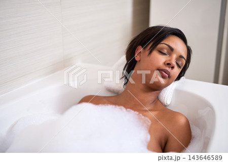 Bubble, bathtub and woman relax in bathroom for peace, calm and sleeping for beauty at home in the morning. Foam, girl and cleaning in water for skincare, wellness and hygiene health with eyes closed 143646589