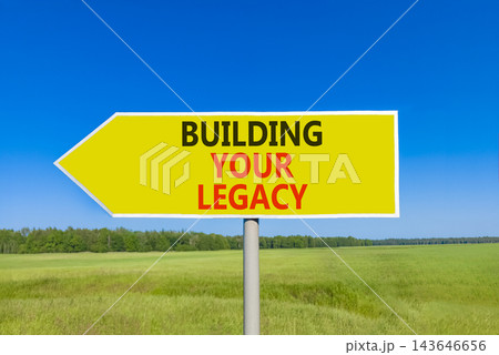 Building your legacy words symbol. Concept words Building your legacy on beautiful yellow road sign. Beautiful blue sky green grass background. Business building your legacy concept. Copy space. 143646656