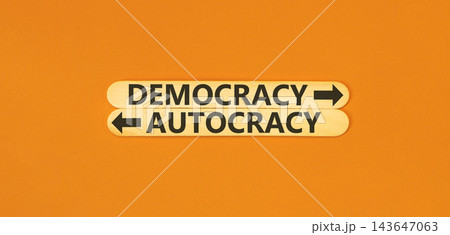 Democracy or autocracy words symbol. Concept words Democracy Autocracy on beautiful wooden sticks. Beautiful orange background. Business democracy autocracy concept. Copy space Democracy or autocracy words symbol. Concept words Democracy Autocracy on beautiful wooden sticks. Beautiful orange background. Business democracy autocracy concept. Copy space 143647063