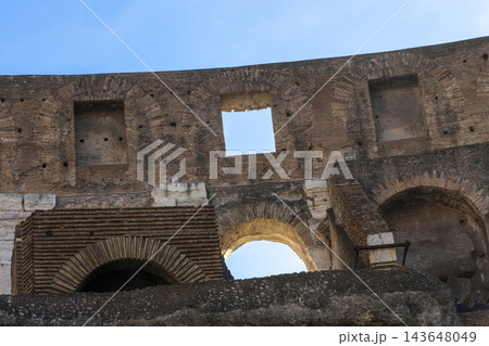Famous Coliseum in Rome. Colosseum, or Coliseum. Part of the wall of an antique stone structure with arches. Italy, Europe. Famous touristic place in the world, Europe. Beautiful blue sky background. Famous Coliseum in Rome. Colosseum, or Coliseum. Part of the wall of an antique stone structure with arches. Italy, Europe. Famous touristic place in the world, Europe. Beautiful blue sky background. 143648049