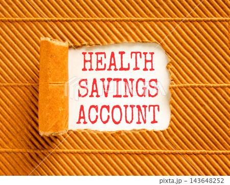 Health saving account symbol. Concept words Health saving account on beautiful white paper. Beautiful brown background. Medical Health saving account concept. Copy space. Health saving account symbol. Concept words Health saving account on beautiful white paper. Beautiful brown background. Medical Health saving account concept. Copy space. 143648252