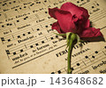 古いネウマ譜の上に置かれた一輪の赤い薔薇 143648682