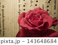 水滴が輝く赤薔薇のクローズアップ アンティーク楽譜背景 143648684