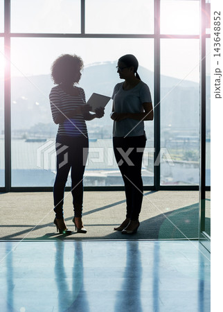 Tablet, women and conversation in office on silhouette for strategy, planning and company growth. People, discussion and collaboration with help or update as copy writer for partnership and teamwork 143648852