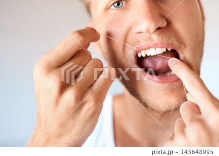 Wellness, portrait and man flossing teeth in home for health, self care and morning routine. Smile, oral hygiene and male person with dental product for fresh breath mouth treatment at apartment. Wellness, portrait and man flossing teeth in home for health, self care and morning routine. Smile, oral hygiene and male person with dental product for fresh breath mouth treatment at apartment. 143648995