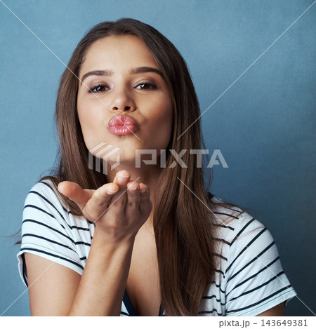 Blow kiss, blue background and portrait of woman for romance, affection and gratitude in studio. Beauty, confidence and face of happy person with flirting emoji, love hand gesture and thank you Blow kiss, blue background and portrait of woman for romance, affection and gratitude in studio. Beauty, confidence and face of happy person with flirting emoji, love hand gesture and thank you 143649381
