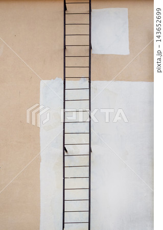 Minimalist Metal Escape Ladder on Textured Urban Building Wall 143652699