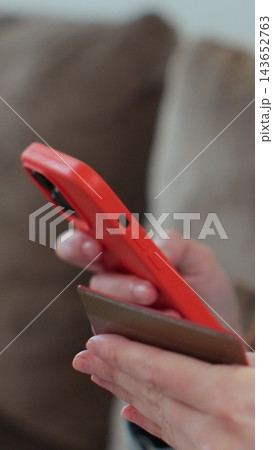Vertical video. Close up of woman hand holding smartphone and credit card doing online shopping at home. Smart phone e-banking service concept. 143652763