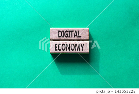 Digital economy symbol. Concept word Digital economy on wooden blocks. Beautiful green background. Business and Digital economy concept. Copy space 143653228