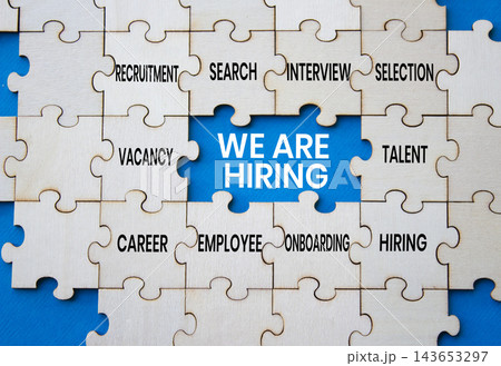We are hiring symbol. Concept words we are hiring on wooden puzzle pieces over blue background. Talent puzzle piece. Recruitment concept. Copy space. 143653297