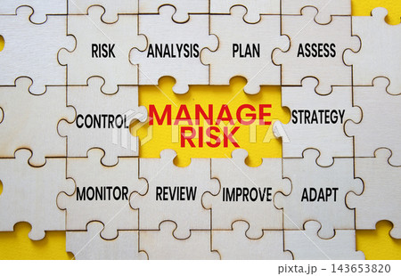 Manage Risk text on wooden puzzle pieces with strategy puzzle piece over yellow background. Business risk management and strategic planning concept with copy space. Manage Risk text on wooden puzzle pieces with strategy puzzle piece over yellow background. Business risk management and strategic planning concept with copy space. 143653820
