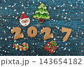 Festive gingerbread cookies for Christmas and New Year 2027 with spices and decorations on a dark wooden table 143654182
