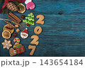 Festive gingerbread cookies for Christmas and New Year 2027 with spices and decorations on a dark wooden table 143654184