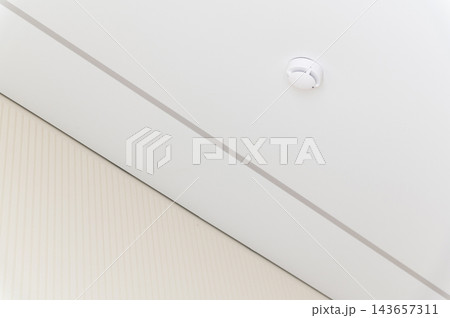Smoke detector mounted on a white ceiling Smoke detector mounted on a white ceiling 143657311