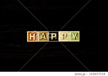 「HAPPY」のカラフルなタイルと木製の文字：幸福、喜び、ポジティブ、祝福を表現するコンセプト 143657534