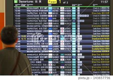 空港の時刻表を確認する旅行客　飛行機の時刻表 143657756
