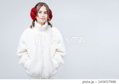 Girl posing wearing warm white fleece jacket red earmuffs hands 143657996
