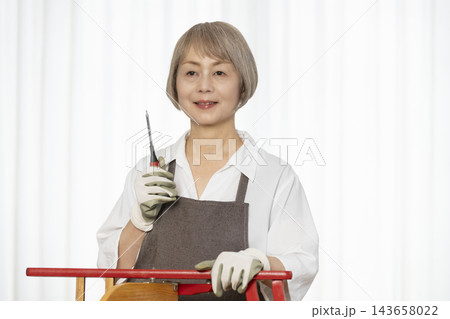 リビングで趣味のDIYで椅子を作るシニア女性 リビングで趣味のDIYで椅子を作るシニア女性 143658022