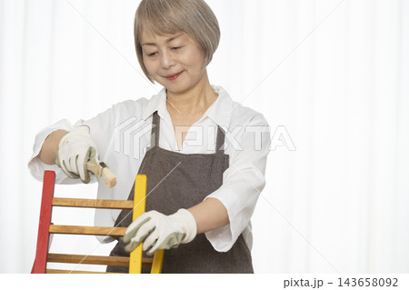 リビングで趣味のDIYで椅子を作るシニア女性 リビングで趣味のDIYで椅子を作るシニア女性 143658092
