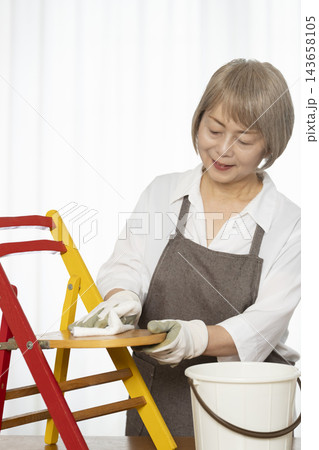 リビングで趣味のDIYで椅子を作るシニア女性 リビングで趣味のDIYで椅子を作るシニア女性 143658105