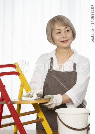 リビングで趣味のDIYで椅子を作るシニア女性 リビングで趣味のDIYで椅子を作るシニア女性 143658107