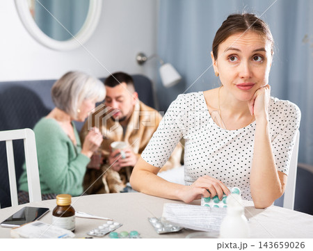 Young wife carefully reads the annotation for medicines and checks the information on Internet 143659026
