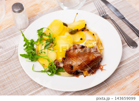 French dish duck confit with arugula on table 143659099