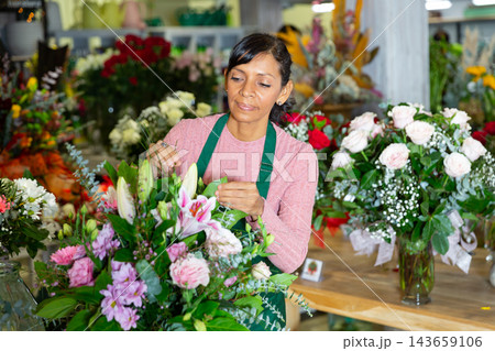 Latin woman florist working in floral shop Latin woman florist working in floral shop 143659106