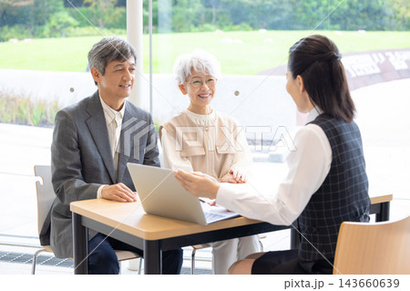 終活　シニア夫婦に説明をする職員 143660639