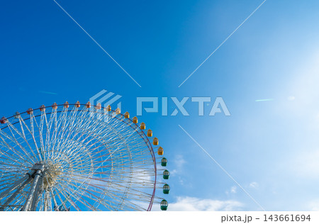 Low angle view of giant colorful ferris wheel against clear blue sky with copy space 143661694