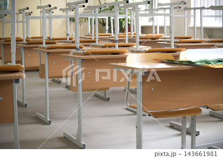 Empty Classroom Desks Arranged in Rows Inside Modern School Building During Bright Daylight 143661981