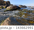 北海道の苔むした岩肌を流れる清流と奥に広がる美しい海や山々の絶景 マクロ撮影 143662991