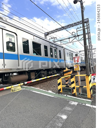 踏切を通過する青いラインの通勤電車 143664253