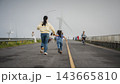mother and preschool child girl holding hand and running on a road on mountain in morning 143665810