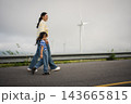 mother and preschool child girl holding hand and walking on a road on mountain in morning 143665815
