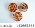 Top view of three Asian rice bowls in takeaway containers featuring beef, spicy pork, and fried chicken over white rice. Arranged on a clean white background for food delivery concepts. 143665823