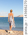 Happy carefree woman enjoying late afternoon walk on white pabbled beach on Pag island, Croatia. 143666270