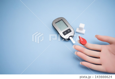 Diabetes concept with blood glucose meter, sugar cubes, blue awareness ribbon and medical gloves on blue background Diabetes concept with blood glucose meter, sugar cubes, blue awareness ribbon and medical gloves on blue background 143666624