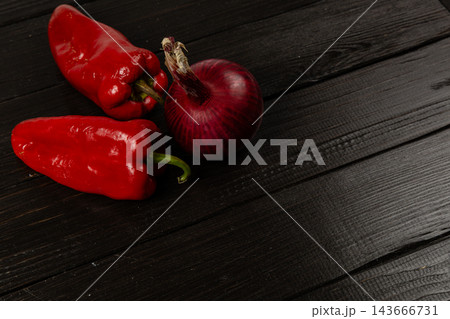 Red chili peppers and onion on a wooden kitchen surface 143666731
