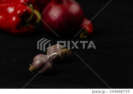 Garlic bulbs with pepper, chili, and onion on a kitchen surface 143666735