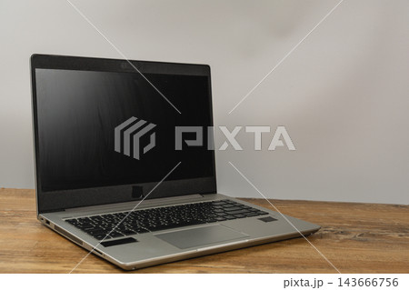 Laptop on a wooden desk in a modern workspace ready for work 143666756